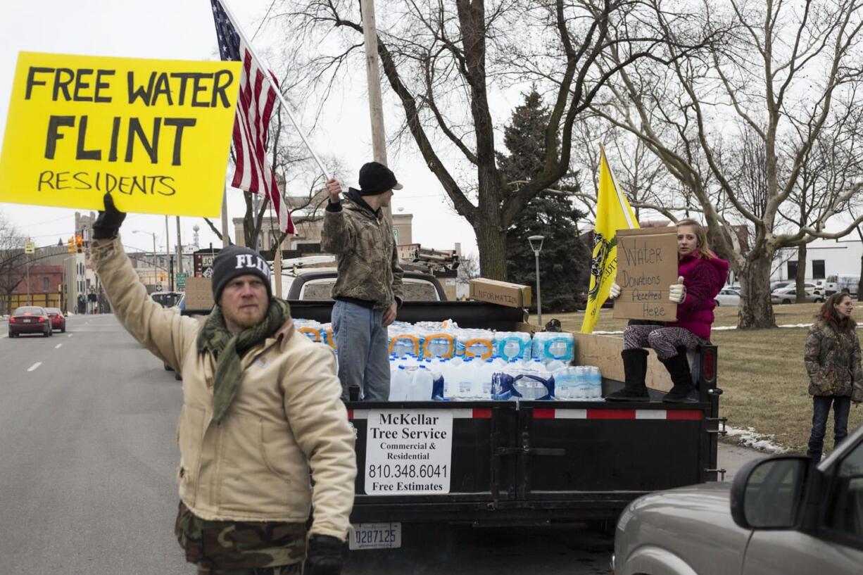 Genesee County Volunteer Militia members and protesters gather for a rally outside of Flint City Hall on Sunday over the cities ongoing water crisis. The militia was handing out free bottled water and water filters.