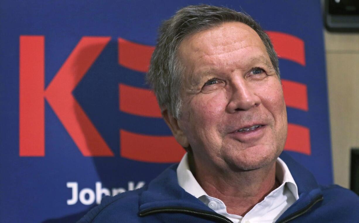 Republican presidential candidate John Kasich answers a question during an interview on his campaign bus Wednesday in Bow, N.H.