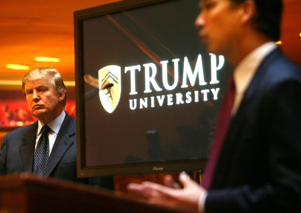 Donald Trump, left, listens as Michael Sexton, president and co-founder of the business education company, introduces him to announce the establishment of Trump University in 2005.