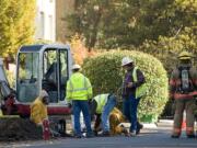 Crews work to fix a gas line leak on East 12th Street between C and D Streets on Thursday.