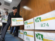 Supporters stack boxes of petitions for Referendum 74 along a wall in the Secretary of State's office to stop Washington's gay marriage law Wednesday in Olympia. The law was blocked from taking effect as opponents filed more than 200,000 signatures seeking a public vote on the issue in November. Preserve Marriage Washington submitted the signatures just a day before the state was to begin allowing same-sex marriages.