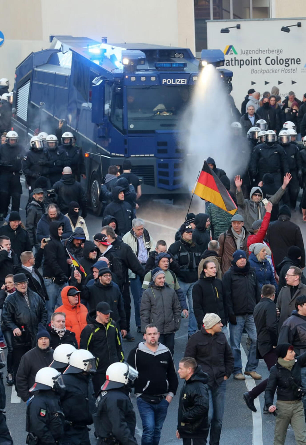 Police drive back right-wing demonstrators using a water cannon during protests Saturday in Cologne, Germany.