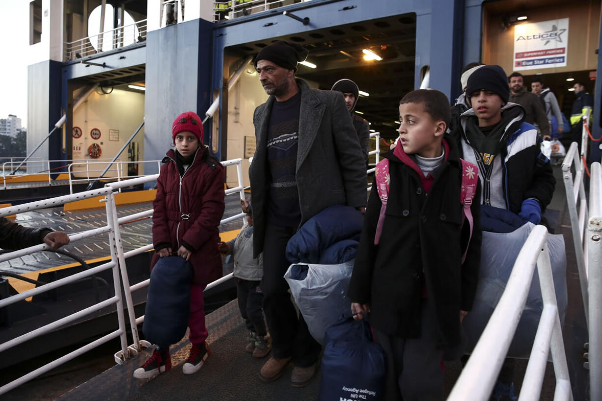 Migrants and refugees disembark from a ferry after their arrival from Greek eastern Aegean islands to the port of Piraeus, near Athens.