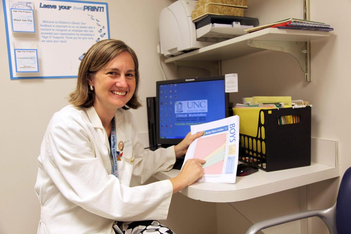 Dr. Eliana Perrin of the University of North Carolina, Chapel Hill holds a stoplight-colored growth chart that helps track when children are overweight for their height.