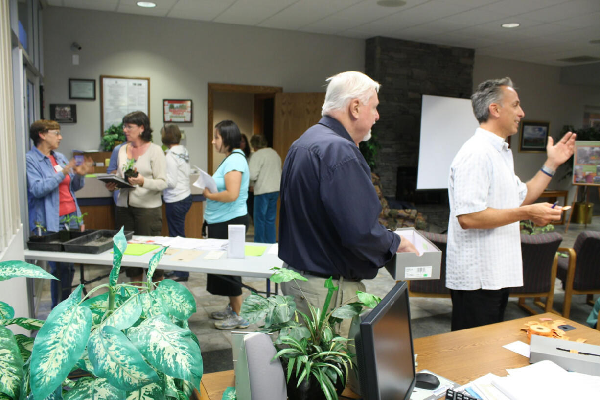 The North Salmon Creek Neighborhood Association meeting ended with president Paul Scarpelli (far right) raffling off tomato plants brought by master gardener Karen Palmer (far left).