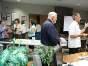 The North Salmon Creek Neighborhood Association meeting ended with president Paul Scarpelli (far right) raffling off tomato plants brought by master gardener Karen Palmer (far left).