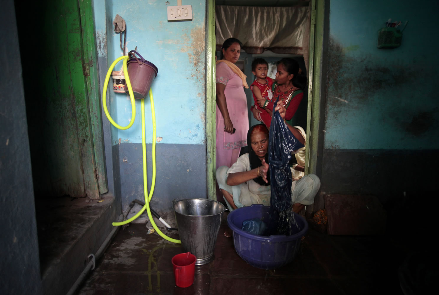 In this May 10, 2012 photo, Fatima Munshi, working as domestic help, washes clothes at a house in Khandwa, India. Living in Australia, Saroo Brierley, 30, reunited with his biological mother, Munshi, in February 2012, 25 years after an ill-fated train ride left him an orphan on the streets of Calcutta.