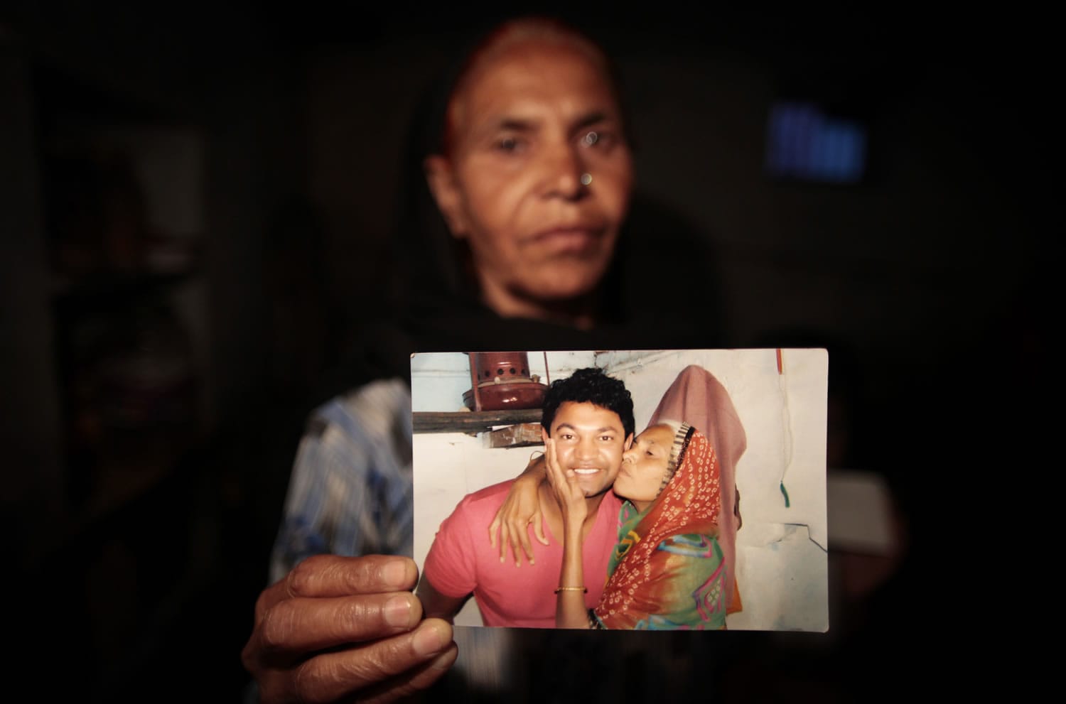 In this May 10, 2012 photo, Fatima Munshi, mother of Saroo, holds up a photo from their reunion in February 2012 at her home in Khandwa, India. Living in Australia, Saroo Brierley, 30, was reunited with his biological mother, Munshi, 25 years after an ill-fated train ride left him an orphan on the streets of Calcutta.