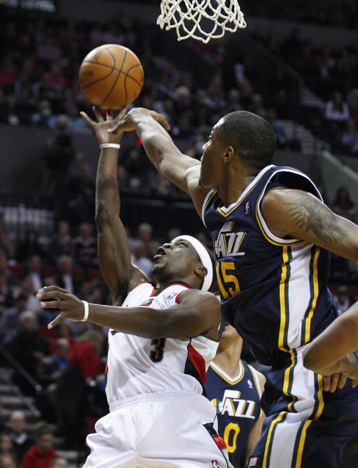 Utah's Derrick Favors (15) defends as Portland's Jonny Flynn (3) goes to the basket Wednesday.