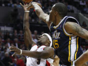 Utah's Derrick Favors (15) defends as Portland's Jonny Flynn (3) goes to the basket Wednesday.