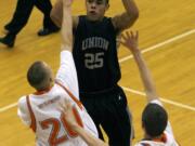 Union guard Jordan Chatman (25) shoots over  Battle Ground defenders Serg Ovchinnikov (20) and Willie Bratcher (32) during boys basketball playoff game at Battle Ground High School.