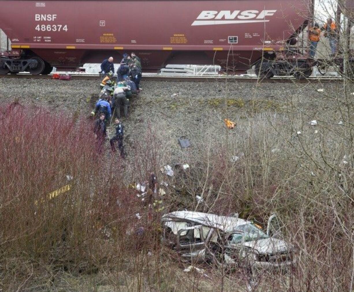 Bill Wagner / The Daily News Emergency personnel haul a litter bearing an injured passenger from the shuttle vehicle which was hit by a northbound train at a private crossing at the Longview Junction near the Harry Morgan Bridge in Kelso.