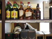 Thomas Burns stocks shelves as he works at a state-run liquor store Wednesday in Seattle.