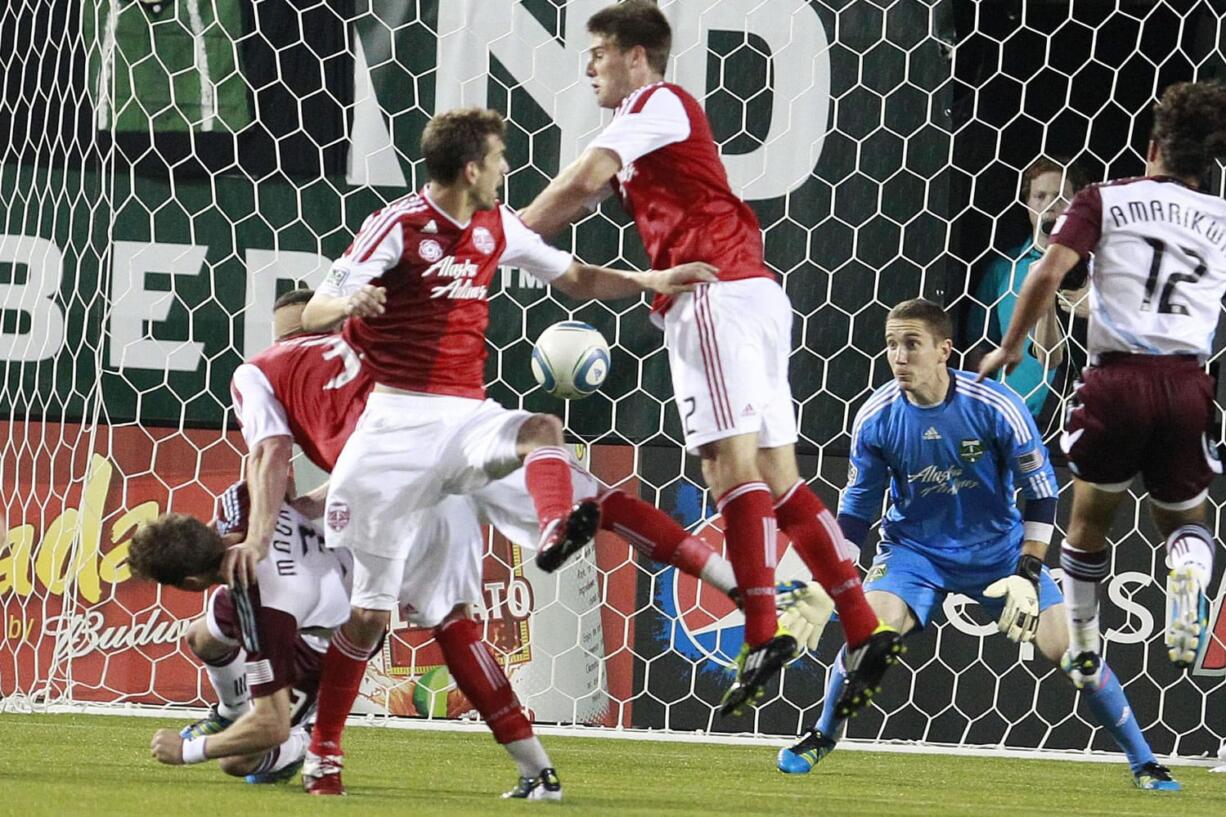 Colorado Rapids' Drew Moor, left, scores in front of Portland Timbers' goalkeeper Troy Perkins during the 90th minute of Saturday's MLS game.