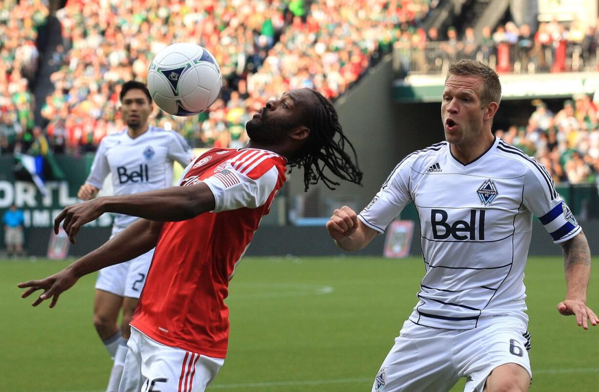 Portland Timbers' Jorge Perlaza, front left, controls the ball as Vancouver Whitecaps' Jay DeMerit (6) looks on in the first half during an MLS soccer game on Saturday, May 26, 2012, in Portland, Ore.