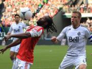 Portland Timbers' Jorge Perlaza, front left, controls the ball as Vancouver Whitecaps' Jay DeMerit (6) looks on in the first half during an MLS soccer game on Saturday, May 26, 2012, in Portland, Ore.