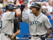 Seattle Mariners' Greg Halman, right, was stabbed to death early Monday in Rotterdam, Netherlands, and his brother was arrested as a suspect, Dutch police said.