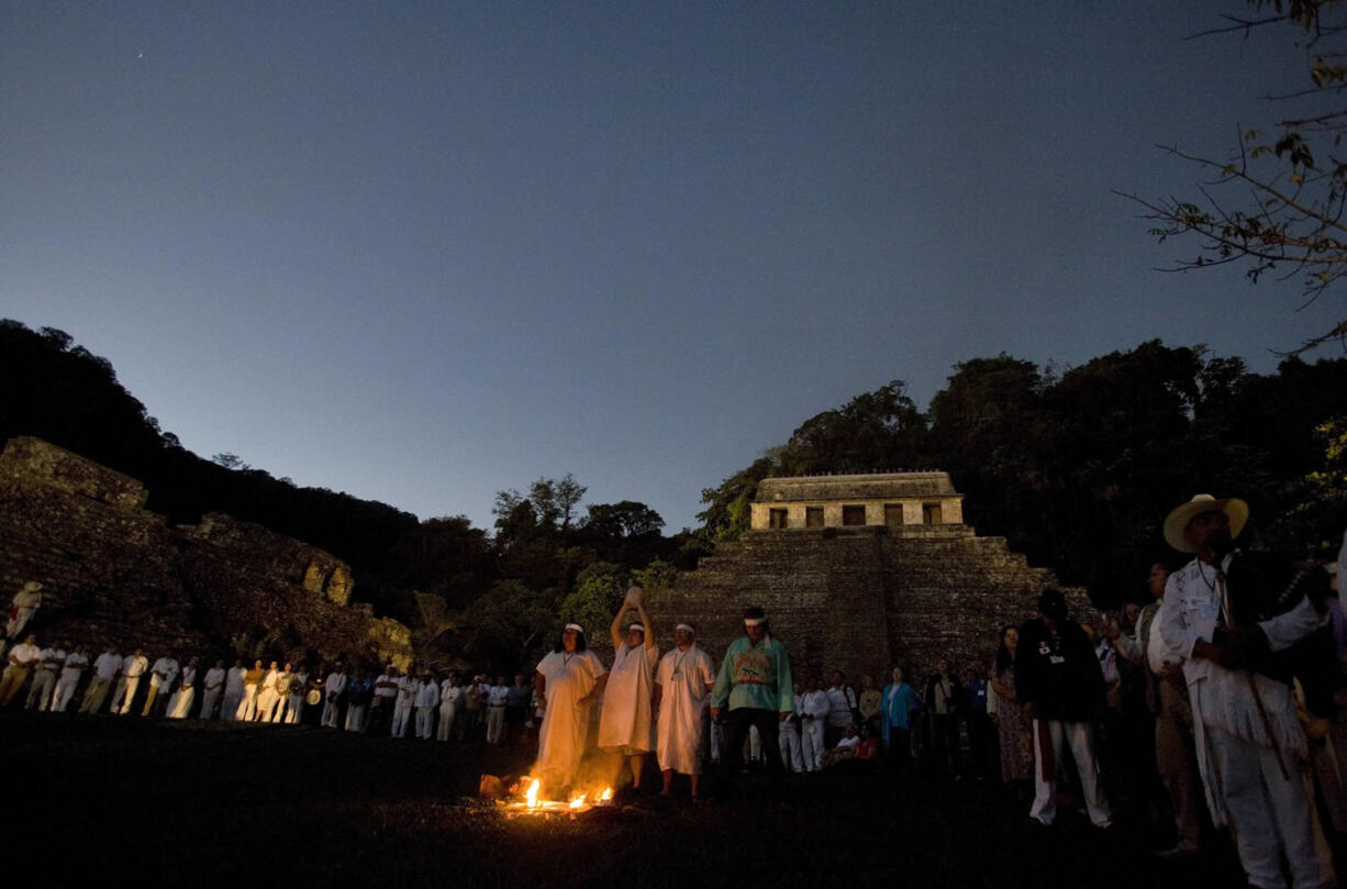 FILE - In this March 10, 2008 file photo, people watch as Mayan indian priests participate in a ceremony while one holds up a crystal skull at the Mayan ruins of Palenque, Mexico. There is a legend that the ancient Maya possessed 13 crystal skulls which, when united, hold the power of saving the Earth. Only a year is left before Dec. 21, 2012, when some believe the Maya predicted the end of the world. While some doomsday theorists may suggest putting together survival kits, people in southeastern Mexico, the heart of Maya territory, plan to throw a yearlong celebration. And to make a profit while they party.