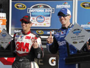 Greg Bifflle, left, of Vancouver, and Carl Edwards, right, hold up their trophies after securing the top two positions during qualifying for the NASCAR Daytona 500 on Sunday. Edwards won the pole for the Feb.