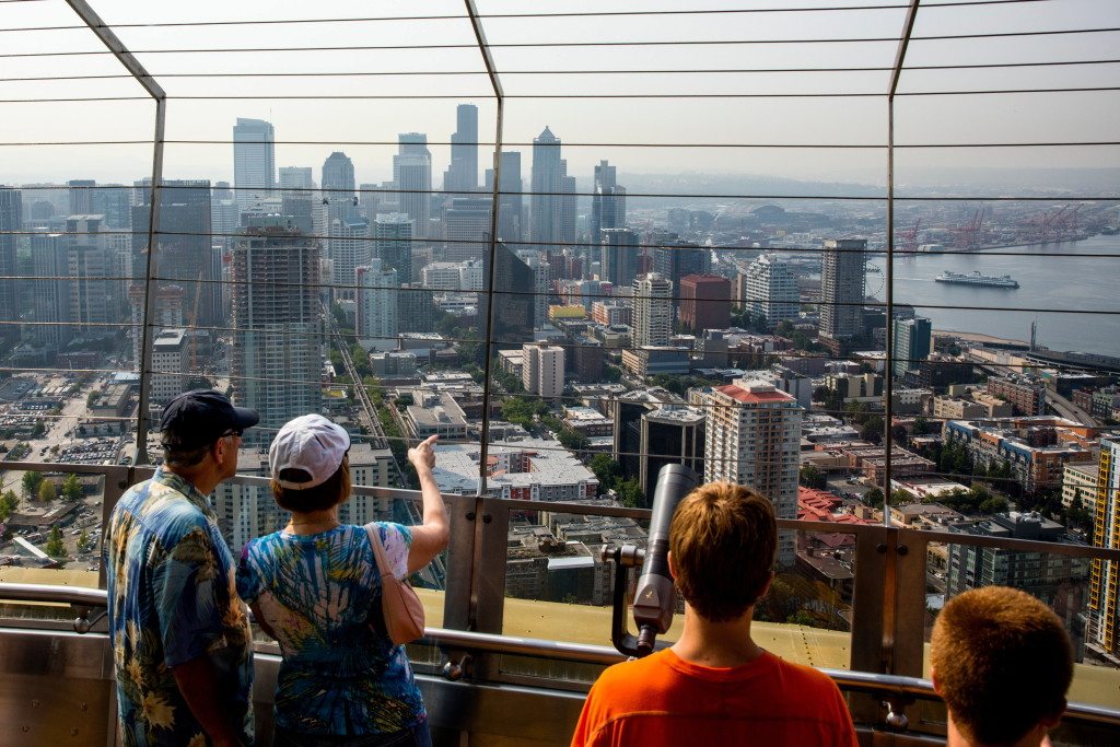 People view the Seattle skyline from the top of the Space Needle in Seattle. Across the country, just 14 percent of neighborhoods manage to be at once affordably priced, walkable and near decent schools. And many of those neighborhoods exist in only two cities: Washington and Seattle, according to a new analysis released Wednesday, by the real estate brokerage Redfin.