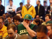 NBA fan Baldwin Poolio, center, reacts to an announcement by Seattle Mayor Mike McGinn and King County executive Dow Constantine about a potential new Seattle NBA and NHL arena on Thursday, Feb.