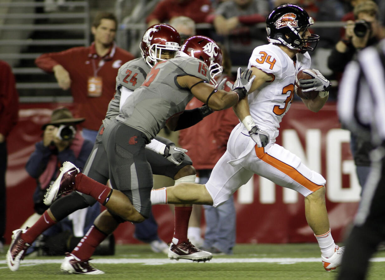 Oregon State's Jordan Jenkins (34) runs for a touchdown ahead of Washington State's Tyree Toomer, center, and Daniel Simmons (24) in the first half Saturday.