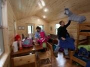 The Thompson family of Tacoma, mom Julianne, dad David and kids Simon, 8; Cecilia, 6; Emilia, 4; and Marilyn, 2, unpack in their cabin at Dash Point State Park in Federal Way in November. &quot;We just wanted to find a place close by and get away from the daily grind,&quot; Julianne Thompson said. (Ellen M.