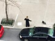 A person walking a dog has laid out a wee-wee pad on a New York sidewalk. Animal behavior experts caution that training dogs to use pads indoors might make it difficult for the dogs to go reliably on outdoor surfaces.