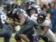 Marshawn Lynch (24) evades Baltimore's Jameel McClain in the second half Sunday.