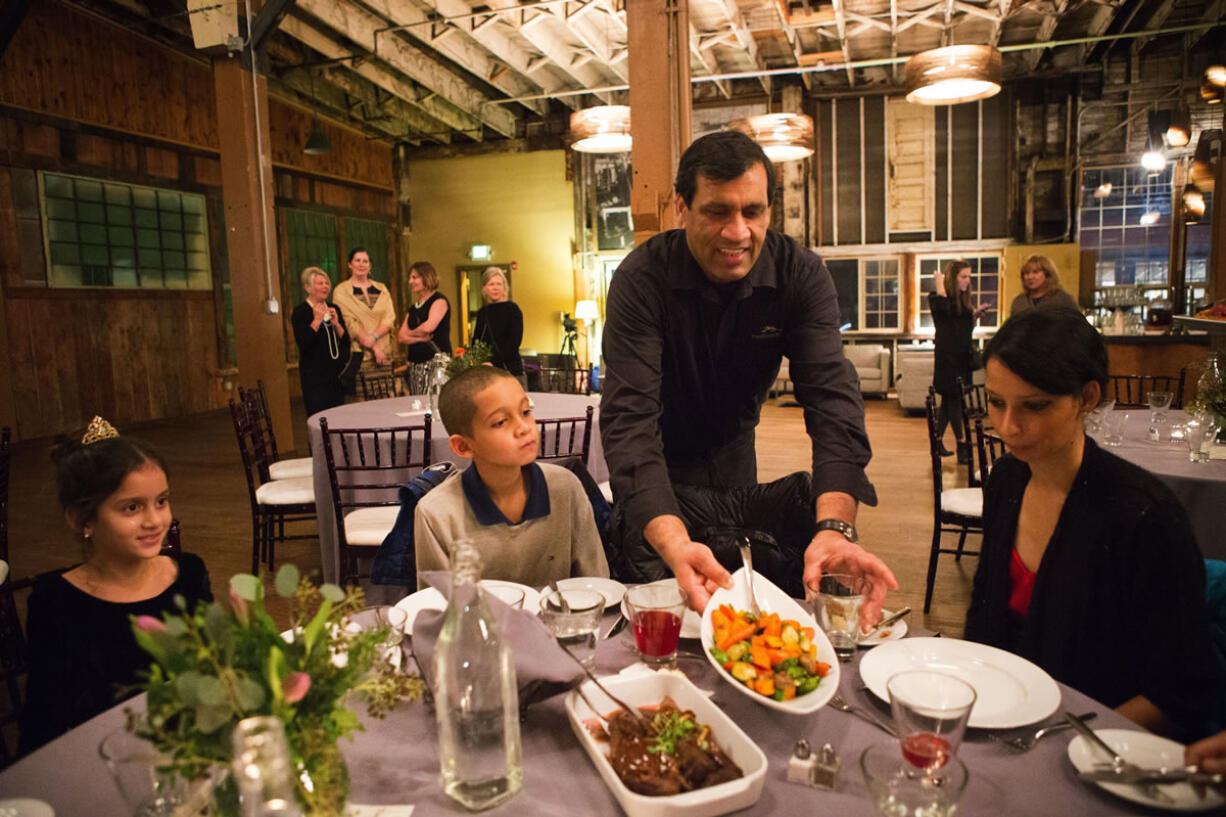 Vinay Pinto, a server of Herban Feast, brings plates of food to the table Jan. 16 for Rebecca, from right, and her son Emmanuel, 9, and niece Sarah, 7.