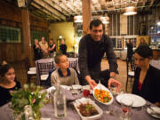 Vinay Pinto, a server of Herban Feast, brings plates of food to the table Jan. 16 for Rebecca, from right, and her son Emmanuel, 9, and niece Sarah, 7.