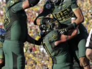 Oregon's Lavasier Tuinei (80), Hockinson High grad Nick Cody (61) and Mark Asper (79) celebrate a touchdown during the first half of the Rose Bowl.