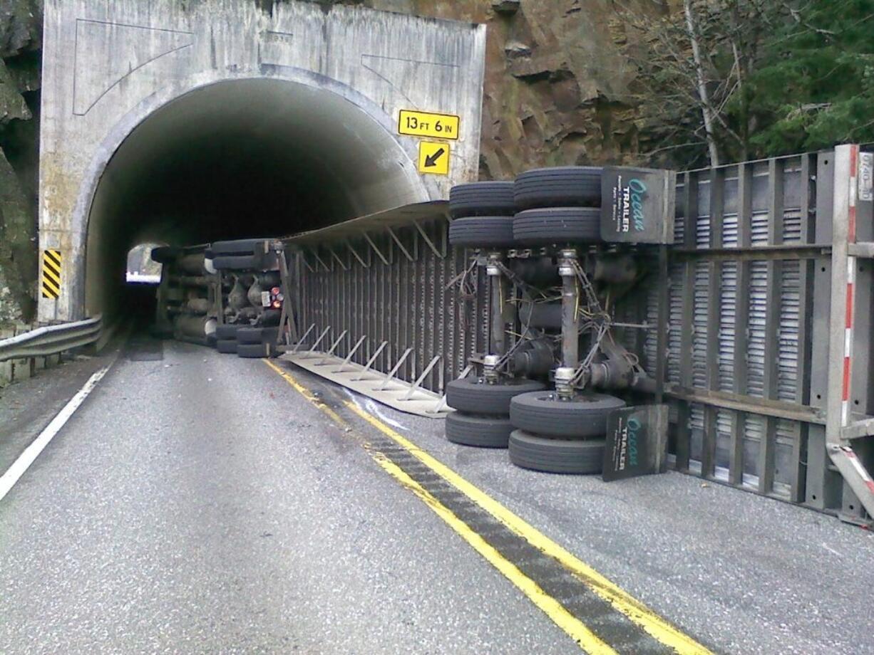 Heavy winds caused a semi truck and trailer to flip on state Highway 14 west of White Salmon Tuesday morning, state patrol said.