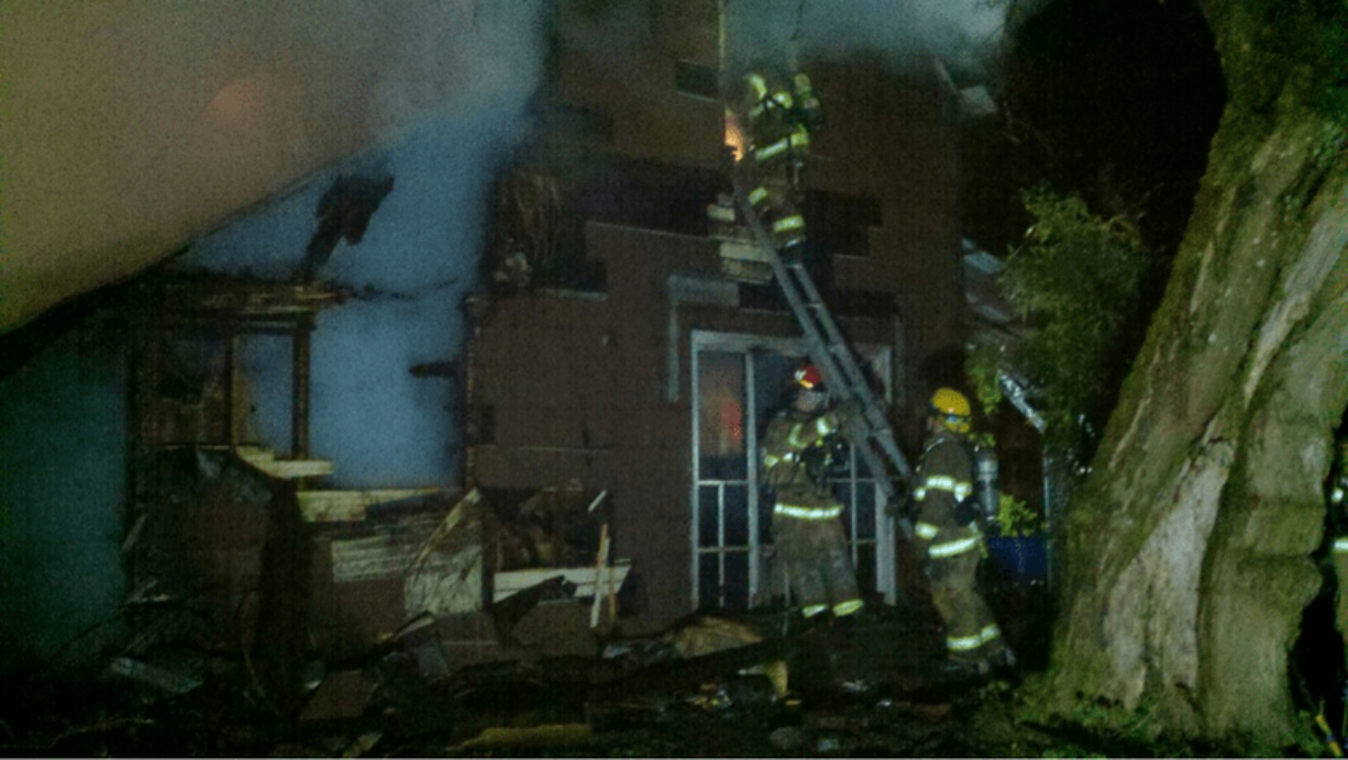 Firefighters enter a house at 26908 N.E. 45th Avenue east of Ridgefield on Tuesday night.