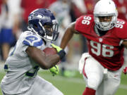 Seattle Seahawks running back Christine Michael (32) runs as Arizona Cardinals linebacker Kareem Martin (96) pursues during the first half of an NFL football game, Sunday, Jan. 3, 2016, in Glendale, Ariz. (AP Photo/Ross D.