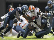 Cleveland's Montario Hardesty runs the ball for 6 yards in the third quarter Sunday as Seattle's strong safety Kam Chancellor (31) and linebacker David Hawthorne defend.