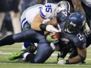 Seattle's Marshawn Lynch is taken down by Dallas' Sean Lissemore during the second half Sunday.