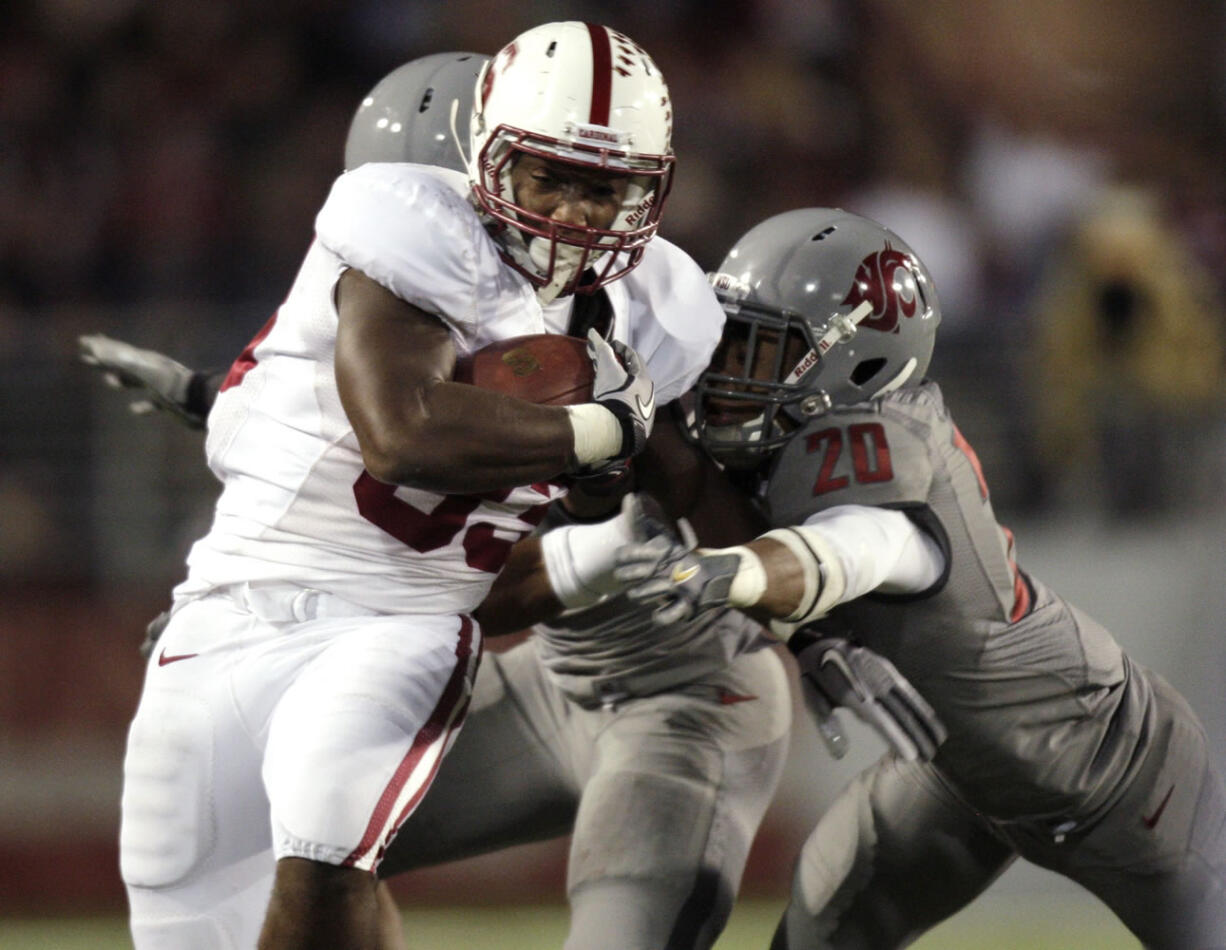 Stanford running back Stepfan Taylor, left, is tackled by Washington State safety Tyree Toomer, obscured, and safety Deone Bucannon (20) during the second half Saturday.