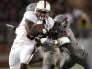 Stanford running back Stepfan Taylor, left, is tackled by Washington State safety Tyree Toomer, obscured, and safety Deone Bucannon (20) during the second half Saturday.