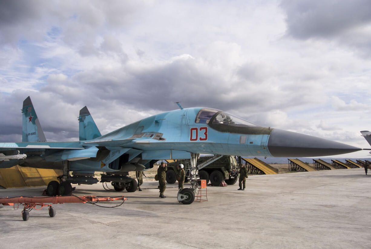 A Russian air force technician reports to a pilot that a bomber is ready for a combat mission at Hemeimeem air base in Syria on Wednesday. Russian warplanes have flown over 5,700 combat missions since Moscow launched its air campaign in Syria on Sept. 30, 2015.