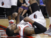 In this Monday, April 9, 2012, photo, Portland Trail Blazers forward LaMarcus Aldridge lies on the court in pain after a collision with another player during an NBA basketball game against the Houston Rockets in Portland, Ore.