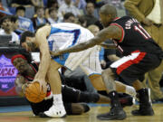 Portland's Gerald Wallace and Jamal Crawford (11) battle for ball possession with New Orleans' Greivis Vasquez  in the second half Monday afternoon.