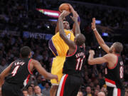 Los Angeles Lakers' Kobe Bryant shoots over Portland Trail Blazers', from left to right, Nolan Smith, Jamal Crawford, and Nicolas Batum during the second half Friday.