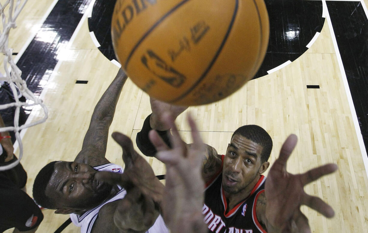 Portland Trail Blazers' LaMarcus Aldridge, right, and San Antonio Spurs' DeJuan Blair, left, reach for a rebound during the first quarter Friday.