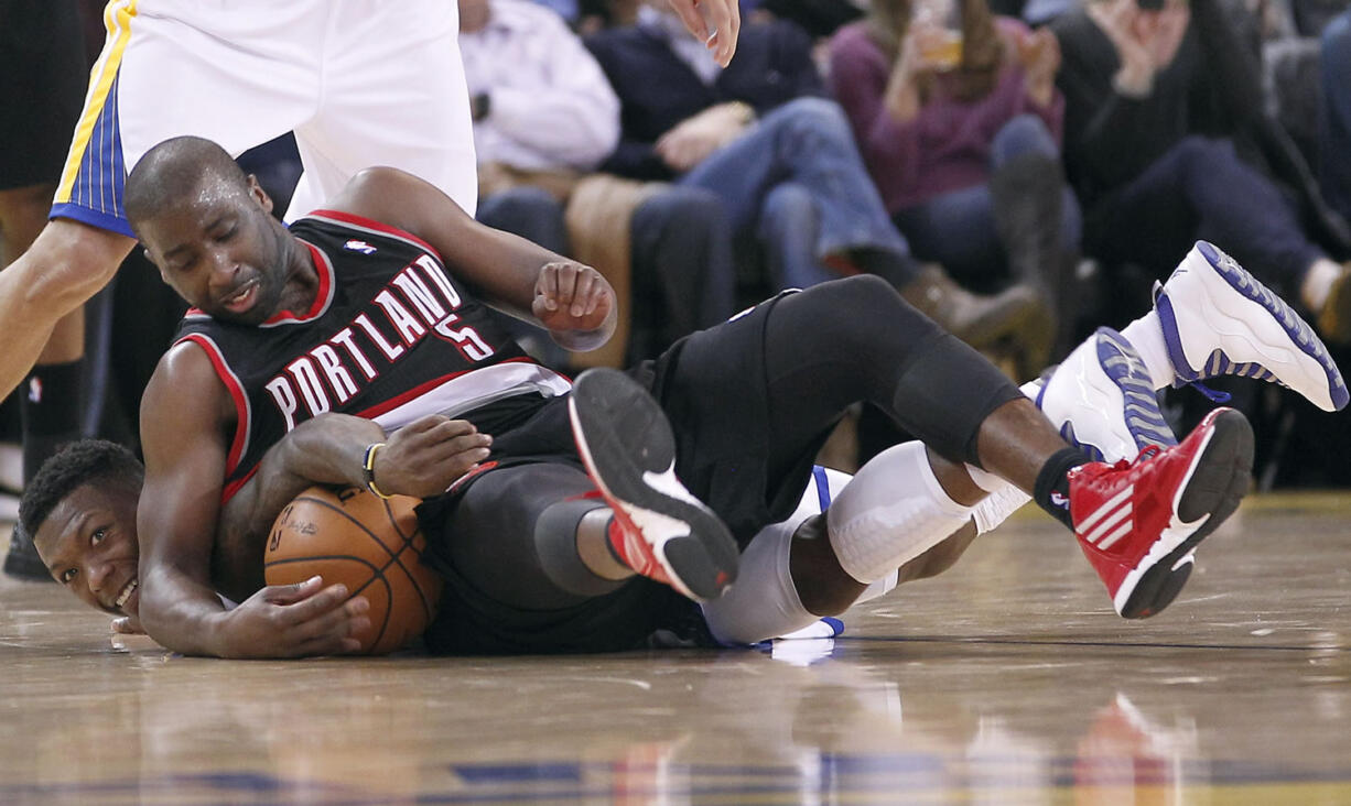 Golden State Warriors' Nate Robinson (2) battles for a loose ball with Portland Trail Blazers Raymond Felton (5) during the second half of an NBA basketball game in Oakland, Calif., Wednesday, Feb. 15, 2012.