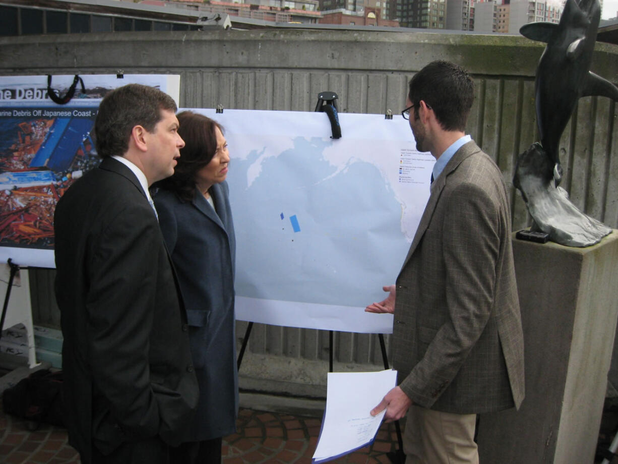 U.S. Sens. Mark Begich and Maria Cantwell talk to Peter Murphy with the marine debris program at the National Oceanic and Atmospheric Administration in Seattle, about the way tsunami debris is expected to cross the Pacific Ocean from Japan to the U.S.