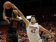 Southern California guard Jordan McLaughlin (11) grabs a rebound in front of Washington State center Conor Clifford (42) during the first half of an NCAA college basketball game, Friday, Jan. 1, 2016, in Pullman, Wash. (AP Photo/Ted S.