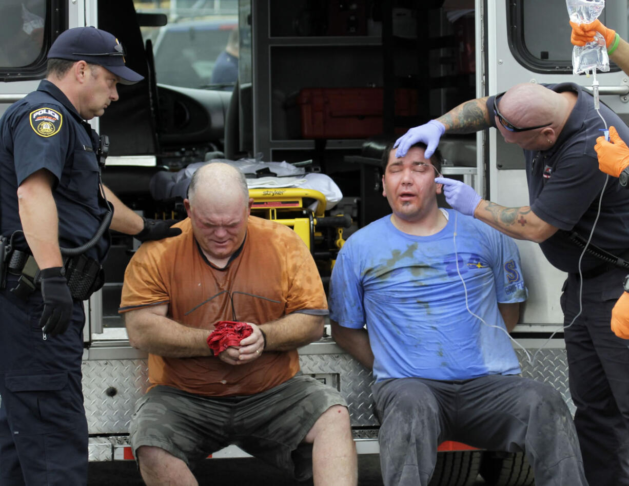 Two unidentified longshoreman receive attention after being maced and detained at port facilities in Longview on Wednesday.