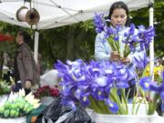 Columbian files
Ker Chang, right, and daughter Hlee set up their Chang Summer Bloom booth at the opening night of the Vancouver Farmers Market Friday in 2010. They grow all their own flowers in Woodburn, Ore.