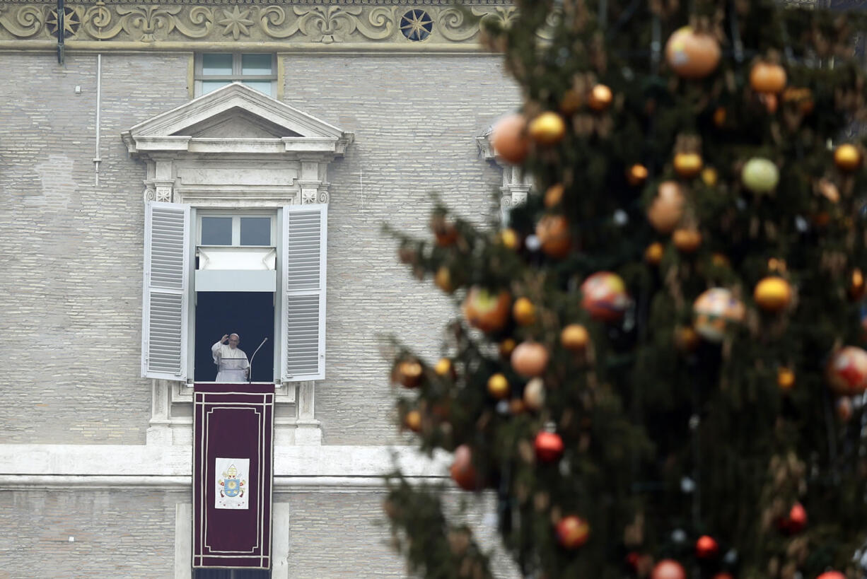 Pope Francis delivers his blessing from his studio&#039;s window during the Angelus prayer in St. Peter&#039;s Square at the Vatican on Friday. Welcoming the new year Friday, Pope Francis called for an end to the ??arrogance of the powerful?? relegating the weak to squalid outskirts of society and to the ??false neutrality?? to conflicts, hunger and persecution triggering a sometimes-deadly exodus of refugees.